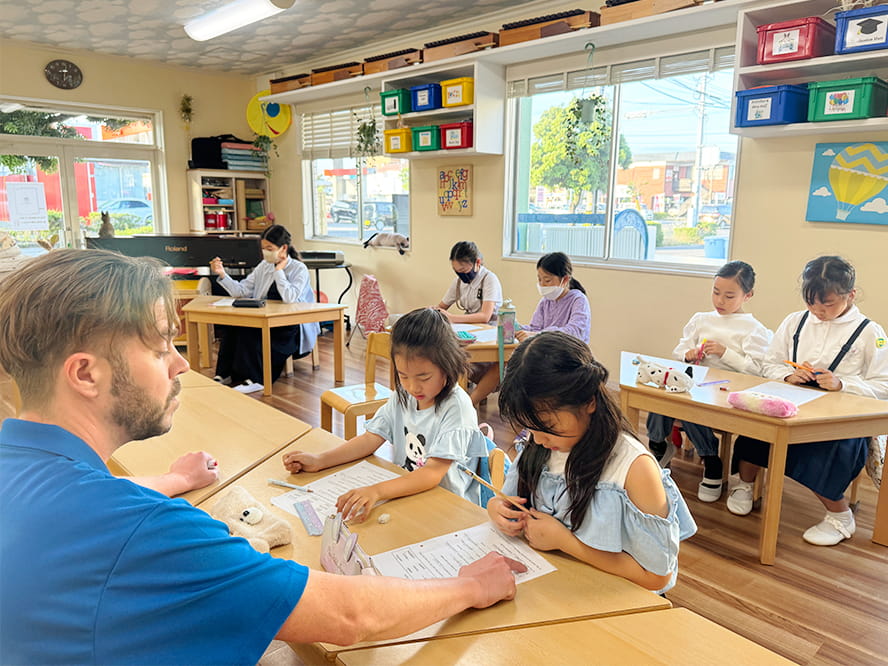 代表の講師に一つひとつ丁寧に教えてもらいながら英語を学ぶ生徒たち