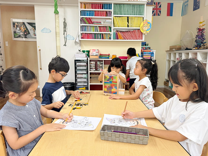 それぞれ絵をかいたりパズルをしたり積み木をしたりしながら学んでいる生徒